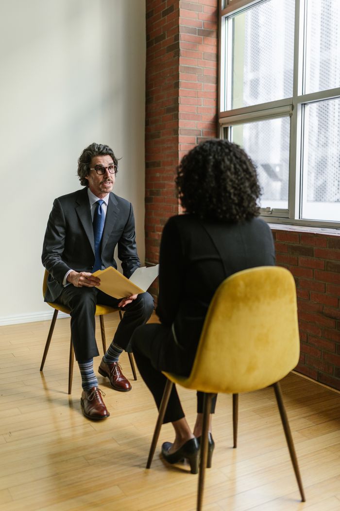 Mastering the First Impression: Your intriguing post title goes here Two professionals in a modern office setting having a conversation. Ideal business and corporate representation.