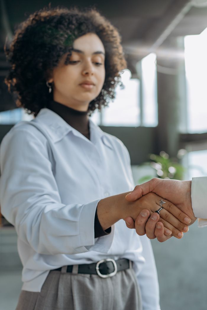 Crafting Captivating Headlines: Your awesome post title goes here Business professionals shaking hands in a modern office setting, symbolizing successful partnership.